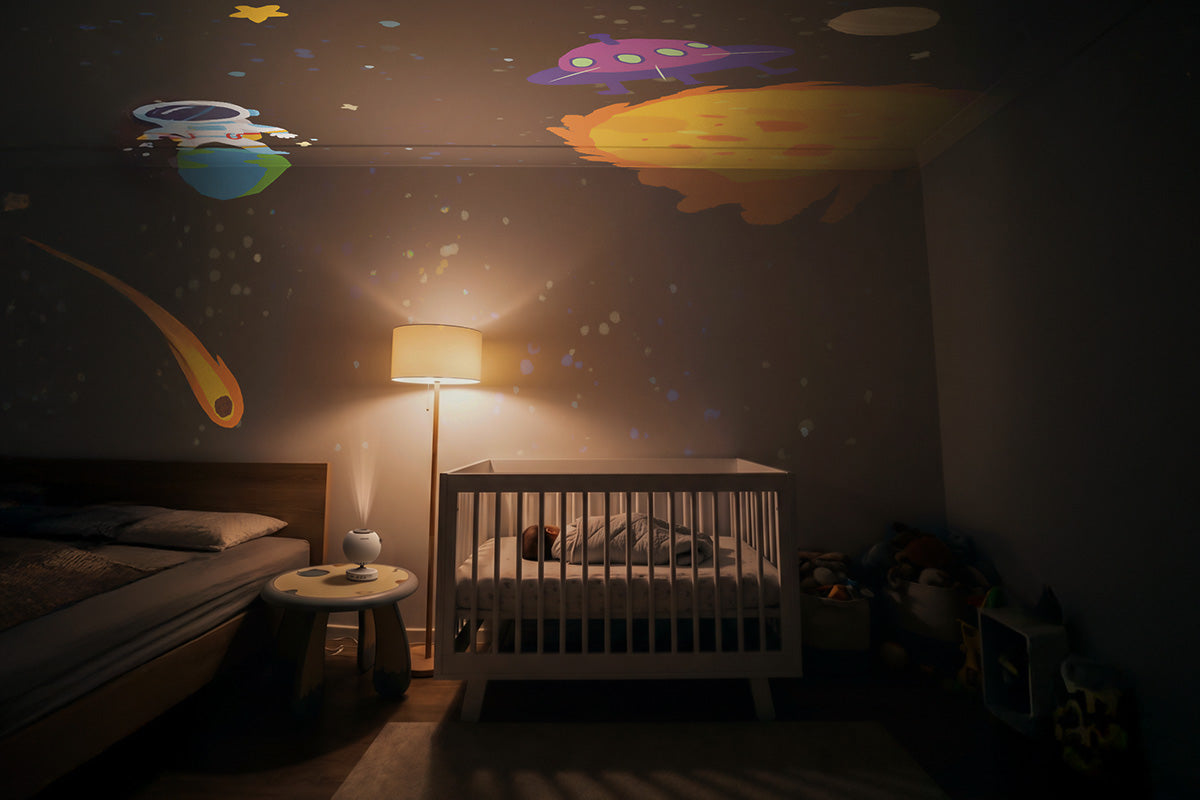 POCOCO galaxy projector casting colorful stars and planets across a nursery ceiling at bedtime.