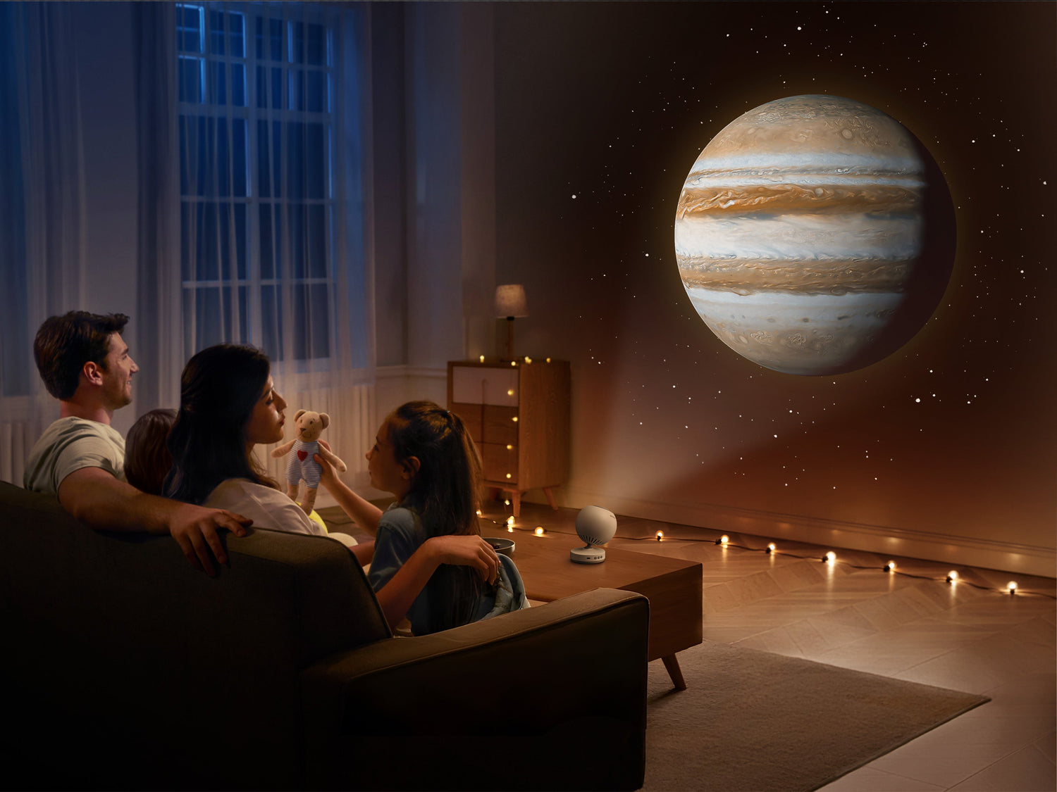 Family sitting together in a room with POCOCO galaxy projector casting star fields on the ceiling