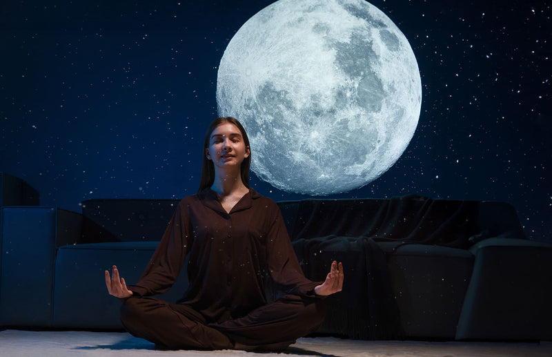 Woman relaxing beneath a moon projection